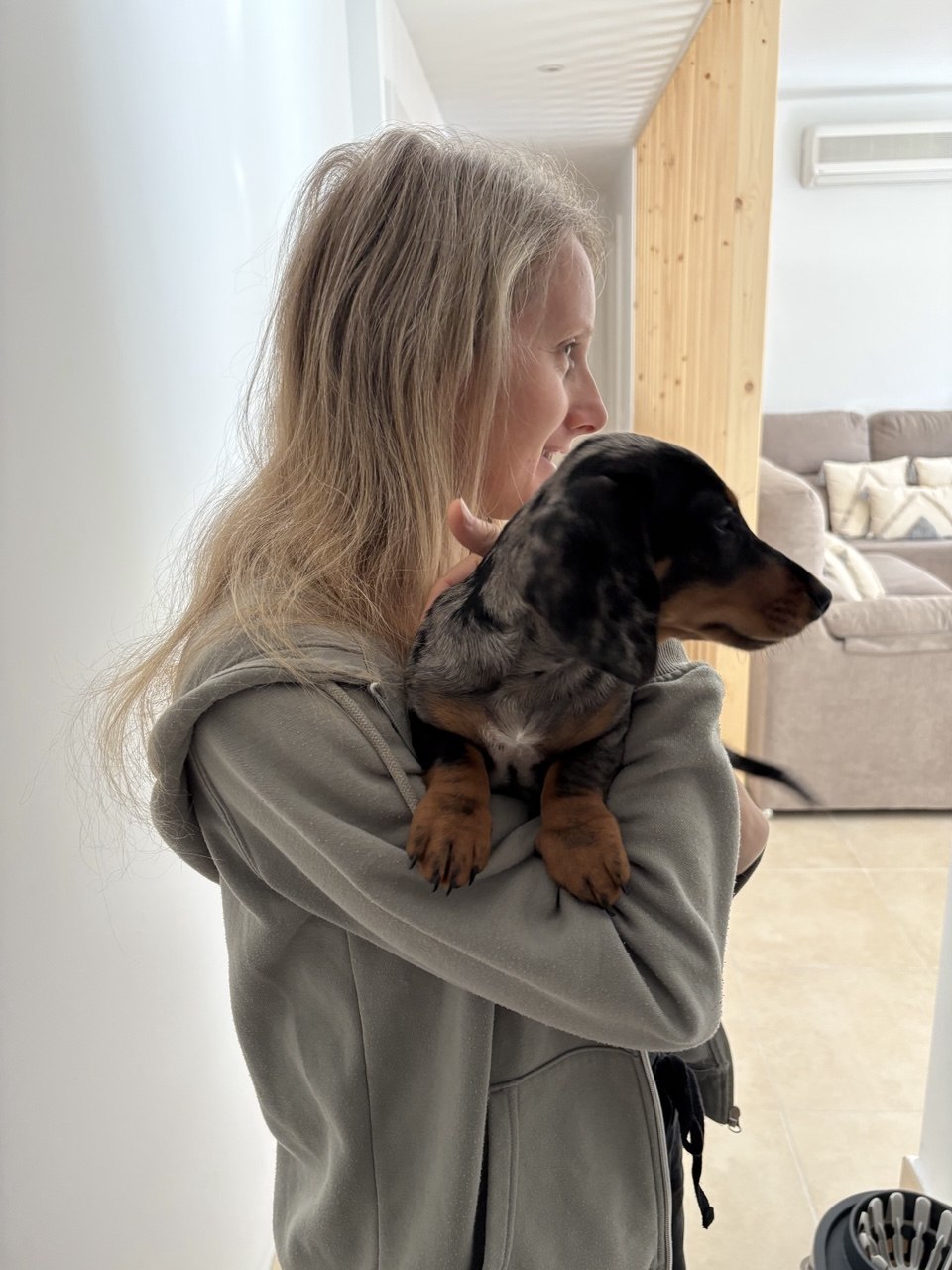 Lía sosteniendo un cachorro de Teckel