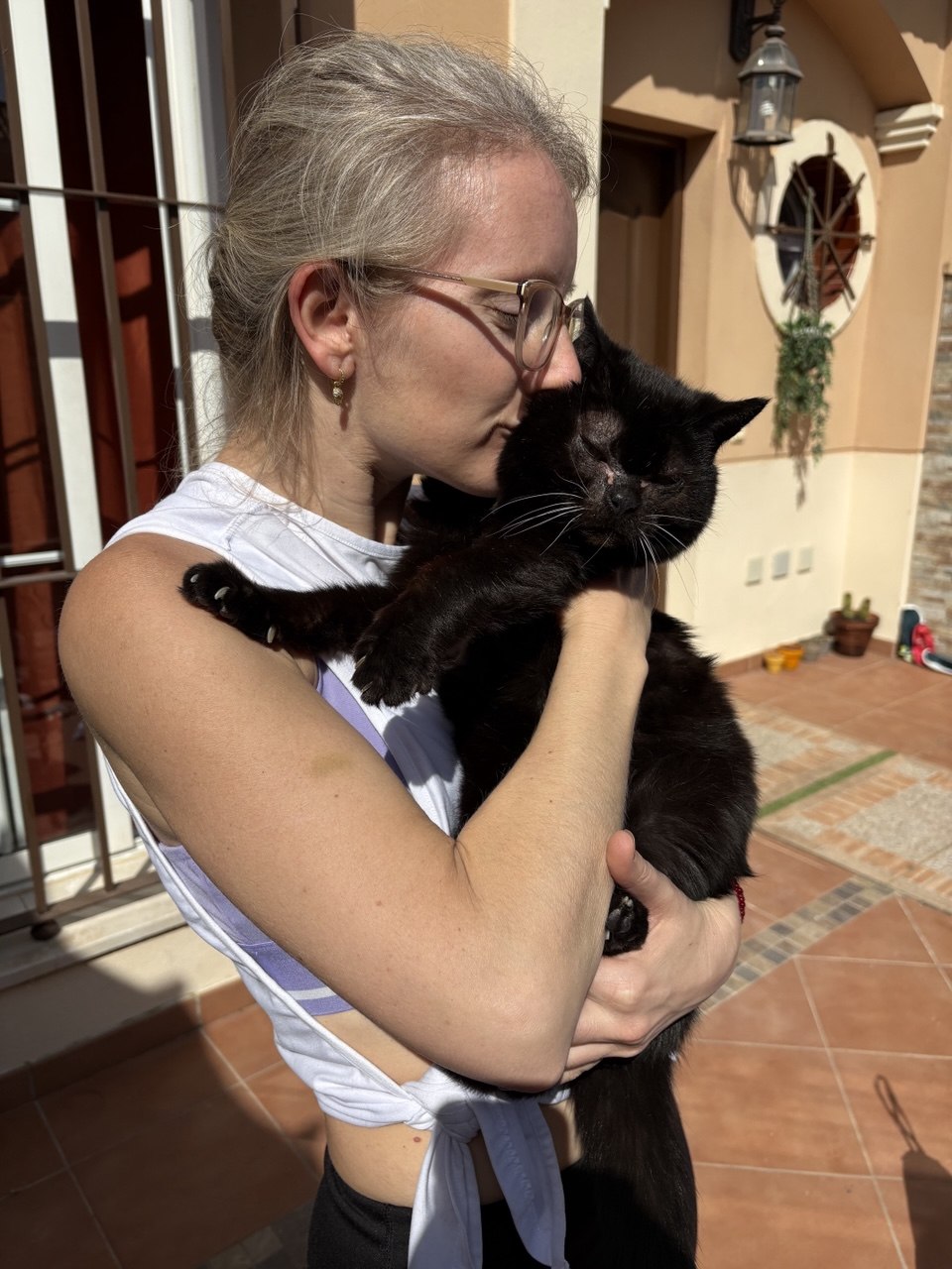 Lía abrazando a un gato negro en casa