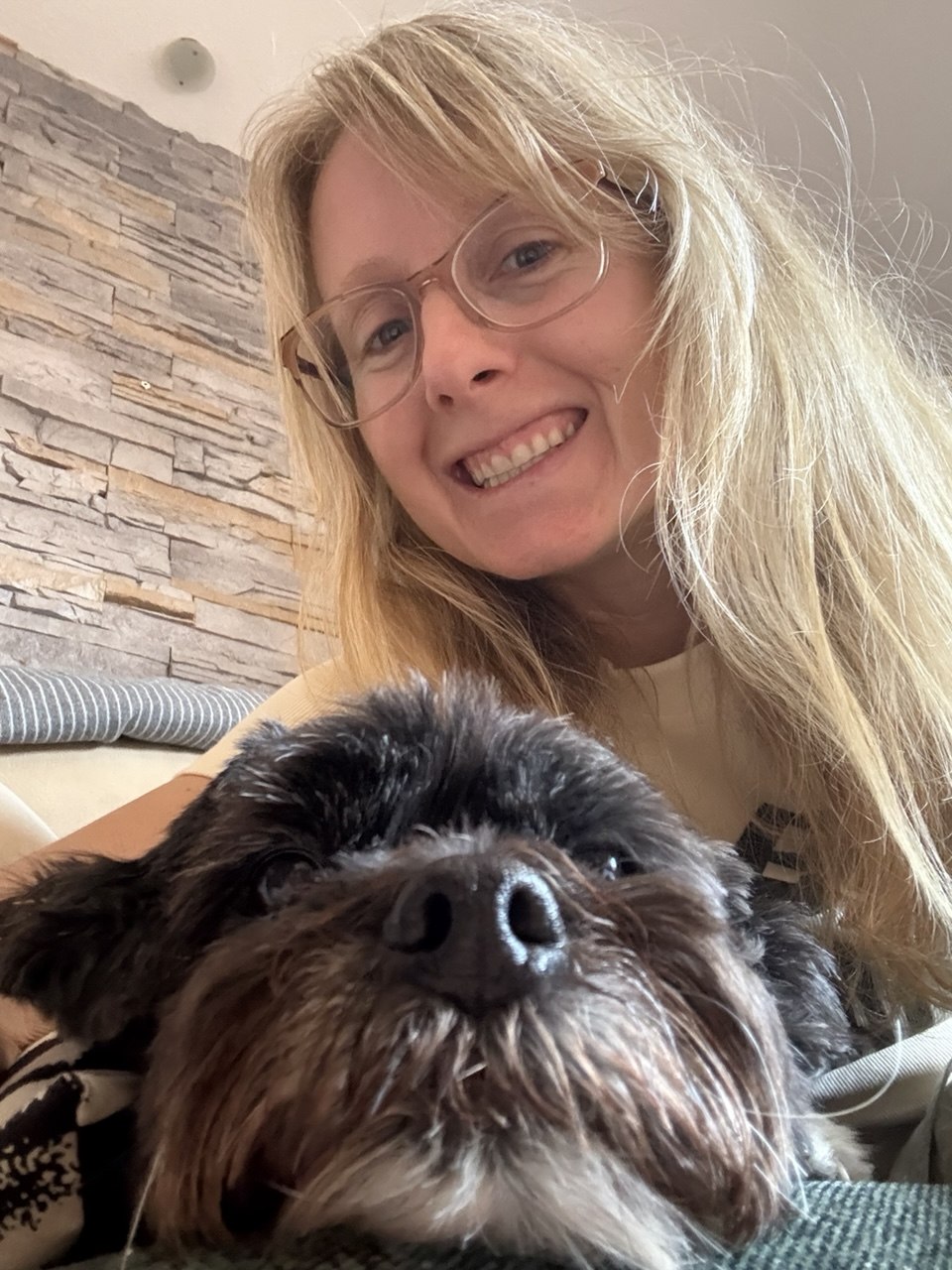 Lía sonriendo con un perrito Schnauzer